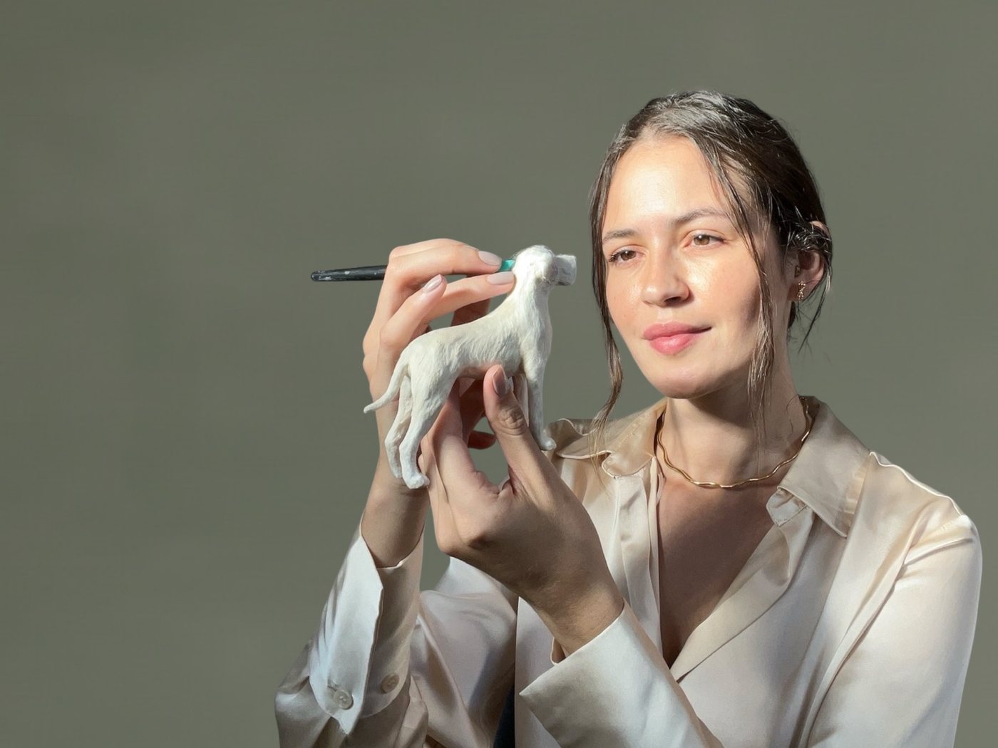 Jiceli Paola segurando uma miniatura realista de cachorro pintada à mão